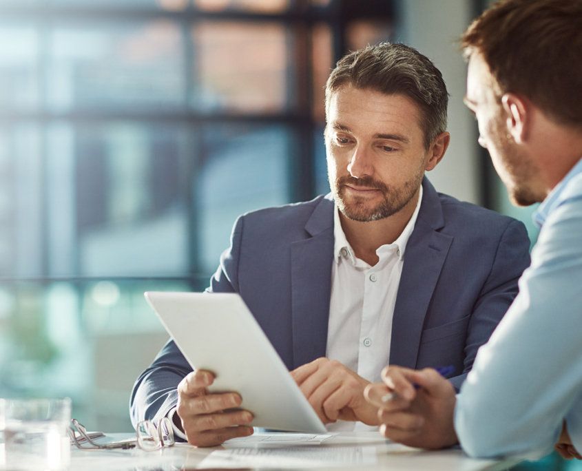 Two Business People Looking At Information On Tablet