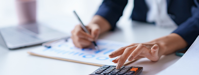 Close-up of the hands of a business woman using a calculator to check financial accounts check the company's expenses and budget_