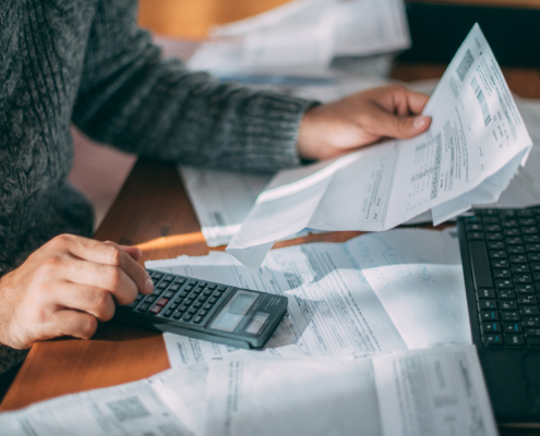 Man looking at financial documents and using calculator