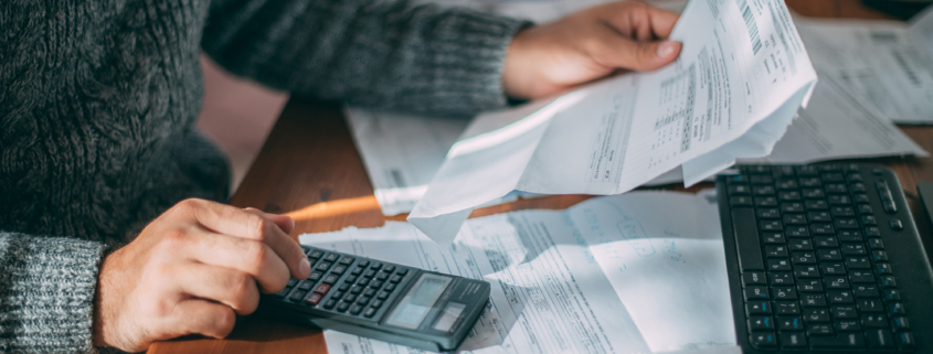 Man looking at financial documents and using calculator