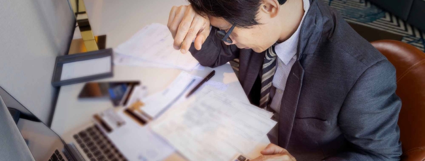 Man stressed with many credit cards wondering how to pay off debts