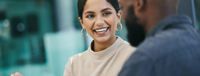 A business woman and business man discussing something and smiling