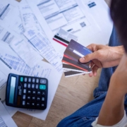 peson-trying-to-pay-dept-holding-credit-cards Man holding credit cards stressfully