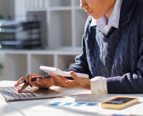 Business Person Looking At Invoices At Office Desk